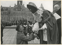 XXXIII-1395-1 Mevrouw J.M. van Walsum-Quispel ontvangt van Sinterklaas een geschenk op het Stadhuisplein. Rechts staat ...