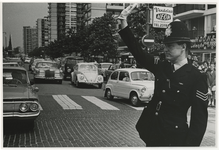 XXXIII-1513 Een Britse politieagent, te gast in Rotterdam, regelt het verkeer in de Karel Doormanstraat.