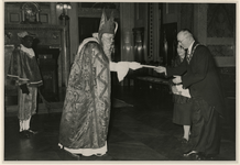 XXXIII-857-01 Burgemeester G.E. van Walsum en echtgenote nemen in de Burgerzaal geschenken in ontvangst van Sinterklaas.