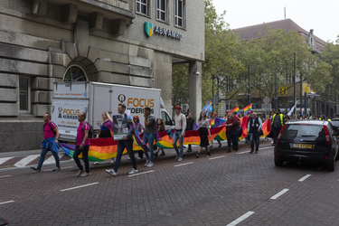 46-21 Pride March Rotterdam tijdens Rotterdam Pride 2021. Betogers in de Aert van Nesstraat dragen een regenboogvlag.