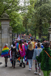 46-94 Pride March Rotterdam tijdens Rotterdam Pride 2021. Betogers met een regenboogvlaggen wandelen het Park in.