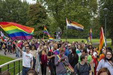 46-97 Pride March Rotterdam tijdens Rotterdam Pride 2021. Betogers met een regenboogvlaggen wandelen door het Park.