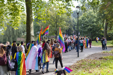 46-98 Pride March Rotterdam tijdens Rotterdam Pride 2021. Betogers met een regenboogvlaggen en borden wandelen door het Park.