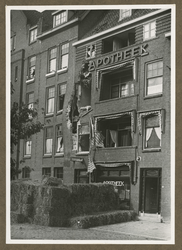 XXXIII-586-01 Gezicht op de Mathenesserdijk met de beschadigde apotheek van A. Vos op nr. 36, als gevolg van het ...