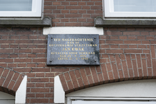 2022-142 Natuurstenen plaquette ter herinnering aan de in 1942 gefusilleerde verzetsman Jan Kwak aan de muur van zijn ...